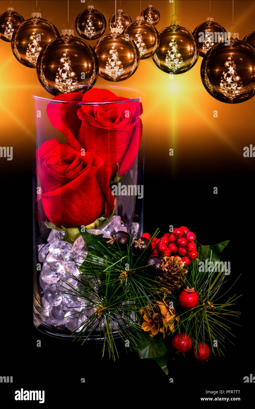 Deux Roses dans un vase avec des perles, des pins, de cônes de pin, des fruits rouges et jaune éclate en arrière-plan avec des ornements de Noël Banque D'Images