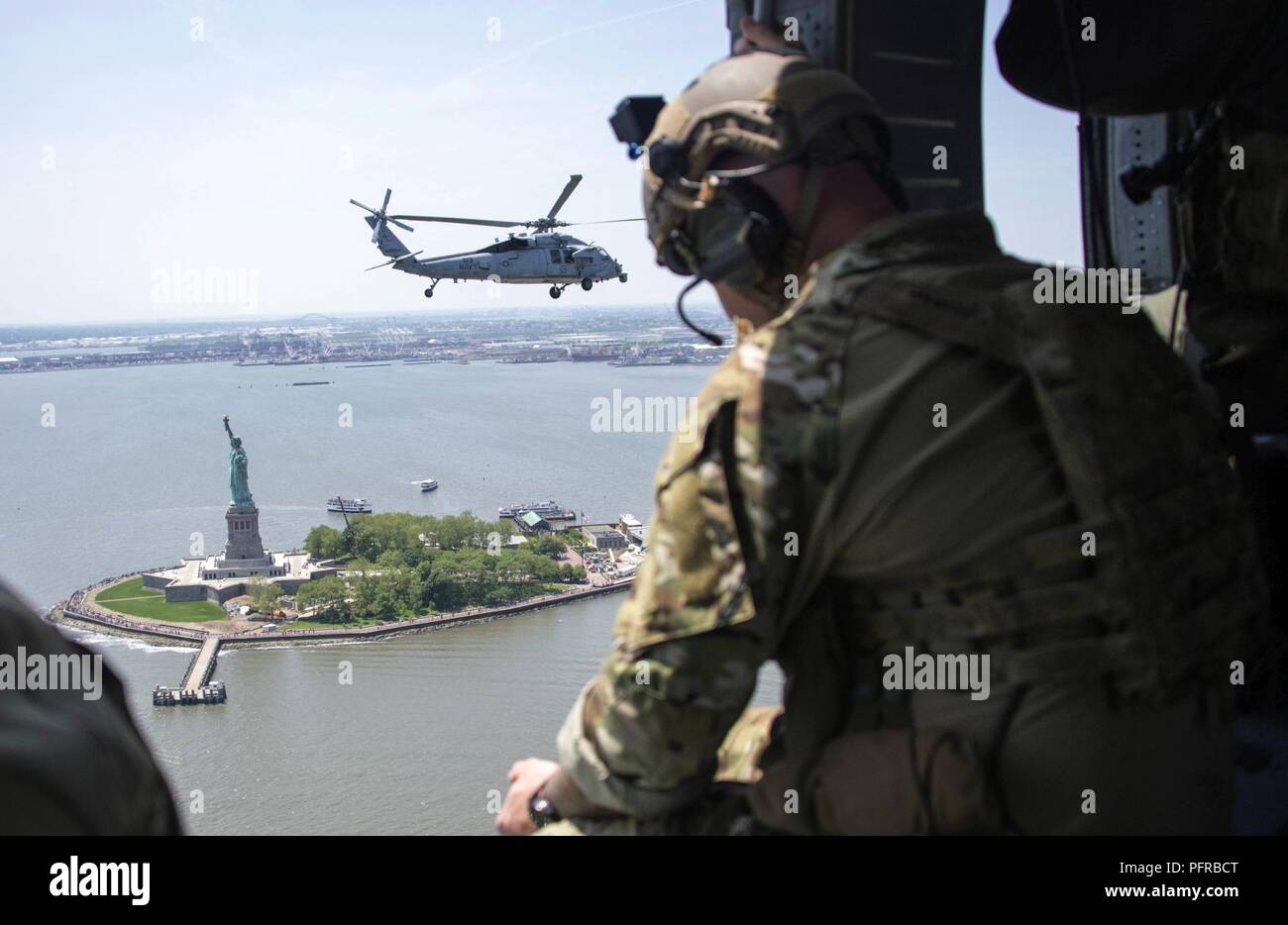 NEW YORK (25 mai 2018) Un technicien des explosifs et munitions affectées à l'élimination des explosifs et munitions (Groupe) EODGRU 2 et un Sea Hawk MH-60S'hélicoptère pour des missions assignées à la 'chiens' poussiéreux de l'Escadron d'hélicoptères de combat de la mer (HSC) 7 Survol de la Statue de la liberté au cours de la Fleet Week New York 2018. Maintenant dans sa 30e année, la Fleet Week New York est la ville est temps-honoré célébration de la mer services. C'est une occasion unique pour les citoyens de New York et la région des trois états pour répondre marins, marines et gardes côte, ainsi que témoin de première main les dernières fonctionnalités de toda Banque D'Images