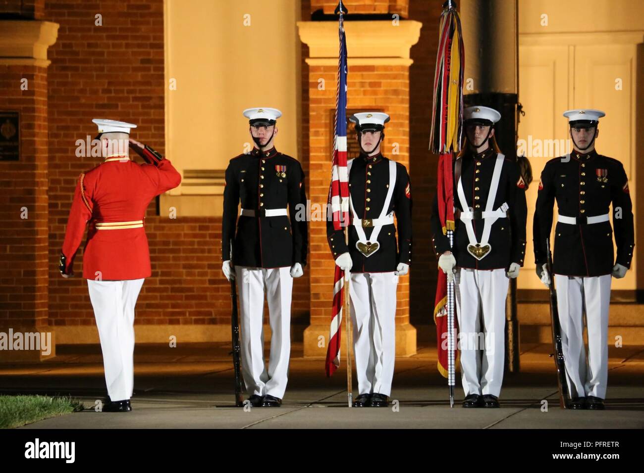 Le Capitaine James D. Foley, directeur général, "le propre" du Commandant de la Marine américaine Drum & Bugle Corps, rend hommage à l'Ensign et le Corps des Marines Couleurs bataille sur le centre à pied au cours d'un défilé vendredi soir chez Marine Barracks Washington D.C., le 25 mai 2018. Les invités d'honneur pour le défilé ont été Gold Star des familles et l'accueil a été lieutenant-général Robert S Walsh, commandant général, Marine Corps Combat Development Command, et commandant adjoint, lutter contre le développement à l'intégration. Banque D'Images