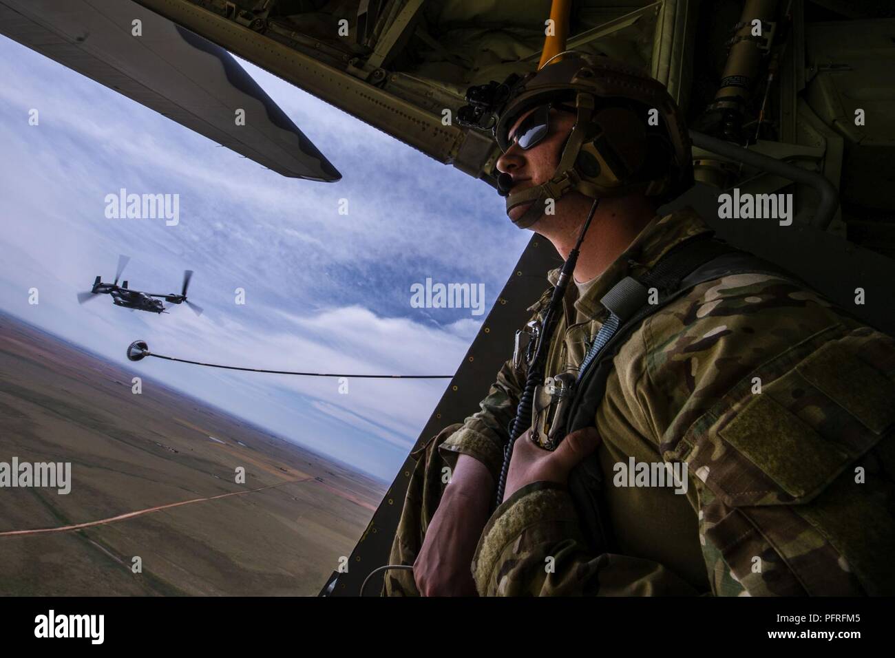 Misclevitz Senior Airman Christopher, 9e Escadron d'opérations spéciales du ministre des Postes, donne sur l'arrière d'un MC-130J Commando II alors qu'un CV-22 Osprey avion vole derrière à Cannon Air Force Base, N.M., 26 mai 2018. Le C-130 et CV-22 ont participé à l'air show en démontrant leurs capacités complet dans un scénario de sauvetage de l'exercice. Banque D'Images
