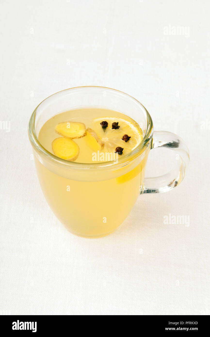 Propolis infusion, épicé avec du gingembre, clou de girofle et de citron dans une tasse en verre, Banque D'Images