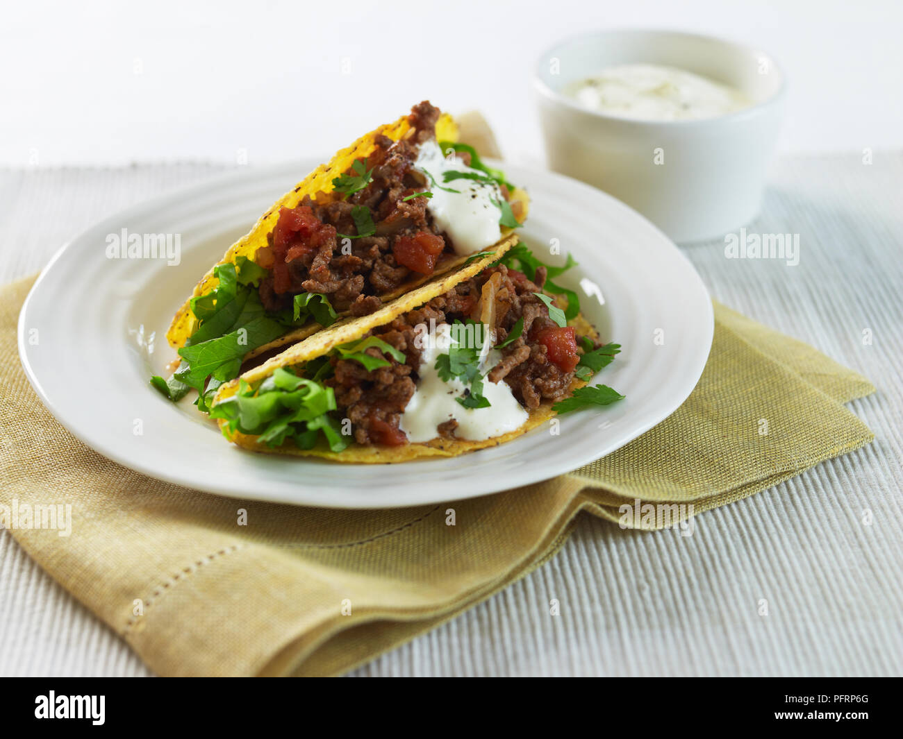 Tacos au boeuf sur une assiette, avec de la crème Banque D'Images