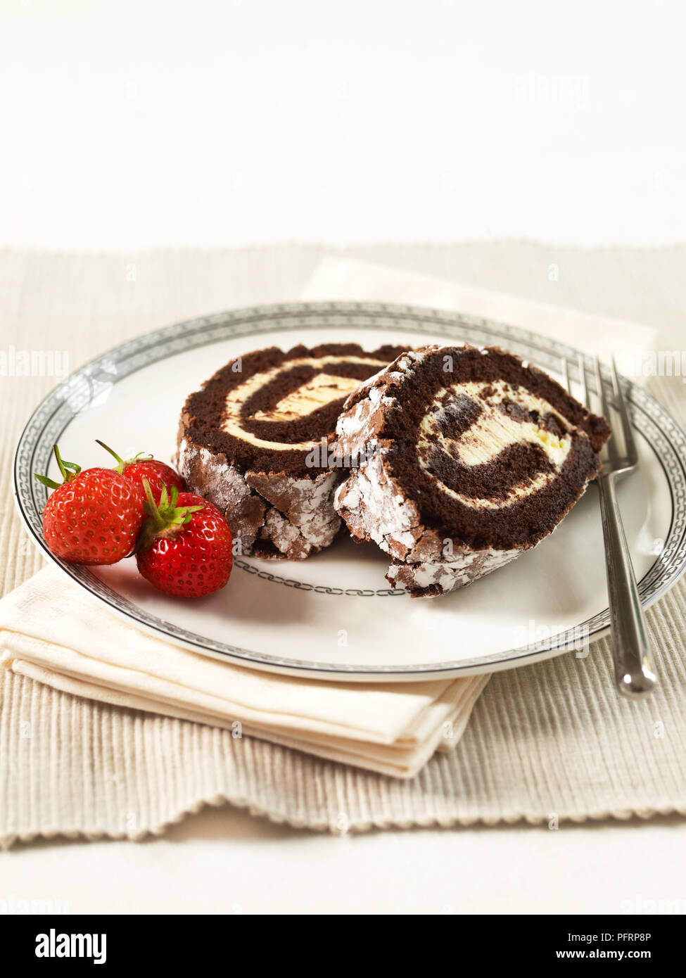 Roulade chocolat, deux tranches sur une assiette, garnir de fraises avec Banque D'Images