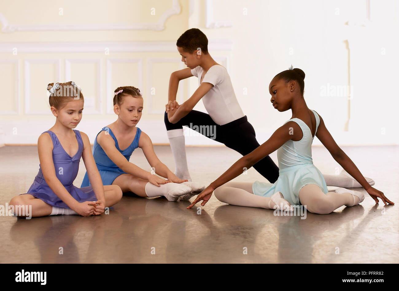 Groupe de jeunes danseurs de ballet faisant des exercices d'étirement Banque D'Images