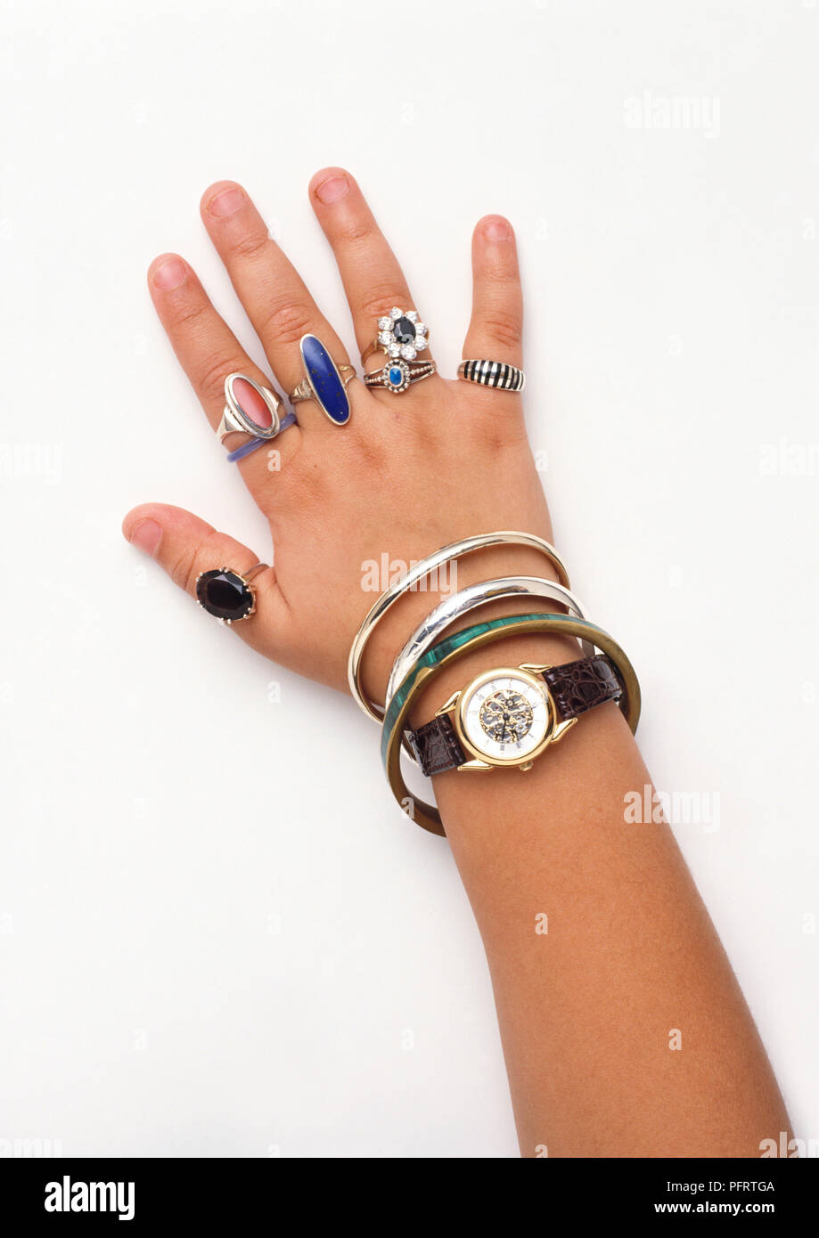 Main de la jeune fille portant un grand nombre de bagues, bracelets et une  montre Photo Stock - Alamy