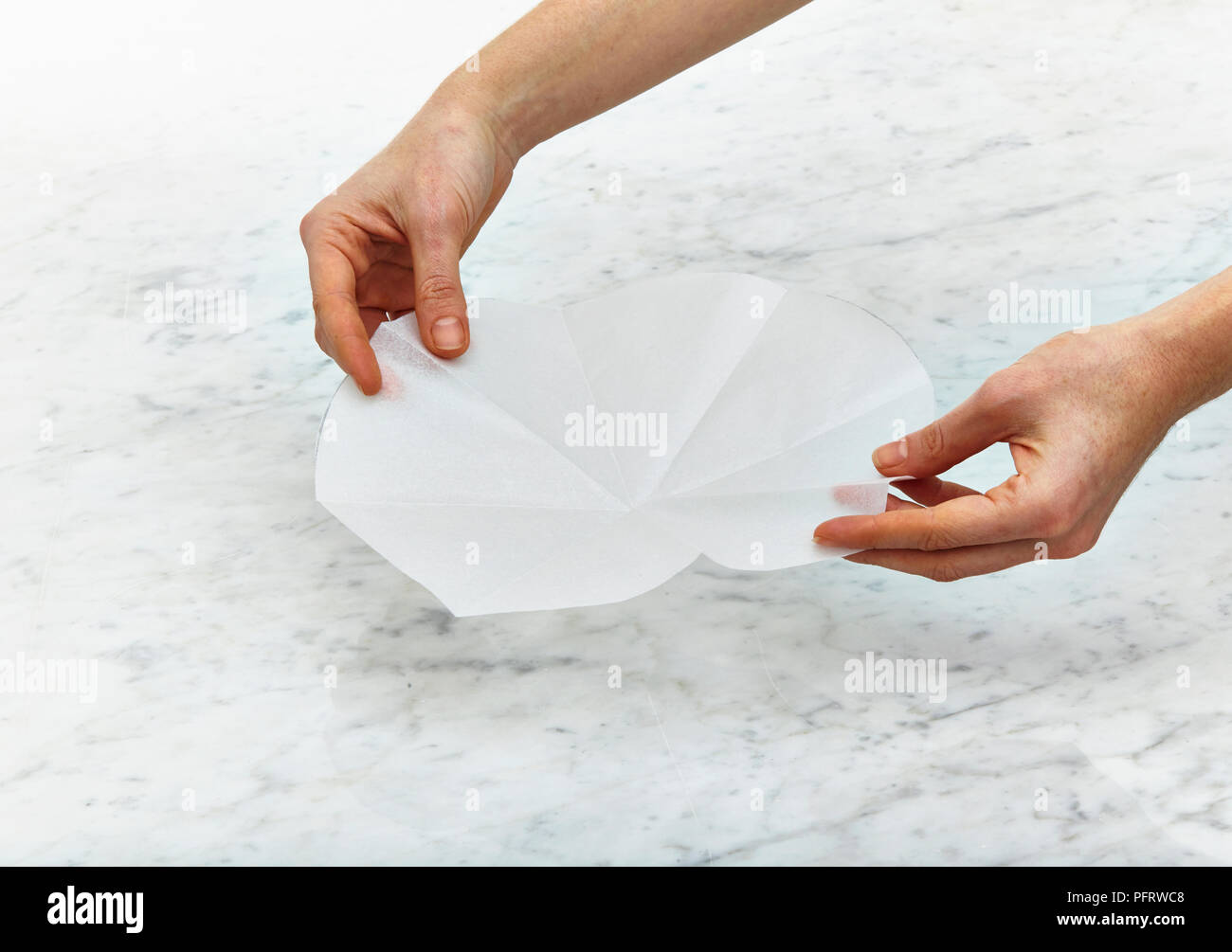 Le pliage du papier sulfurisé pour faire des gâteaux en forme de chapiteau Banque D'Images