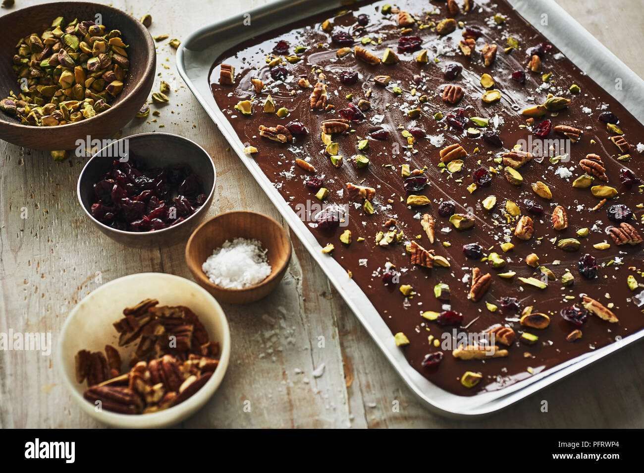 Faire de l'écorce de chocolat noir, de pacanes, pistaches, sel de mer, de canneberges Banque D'Images