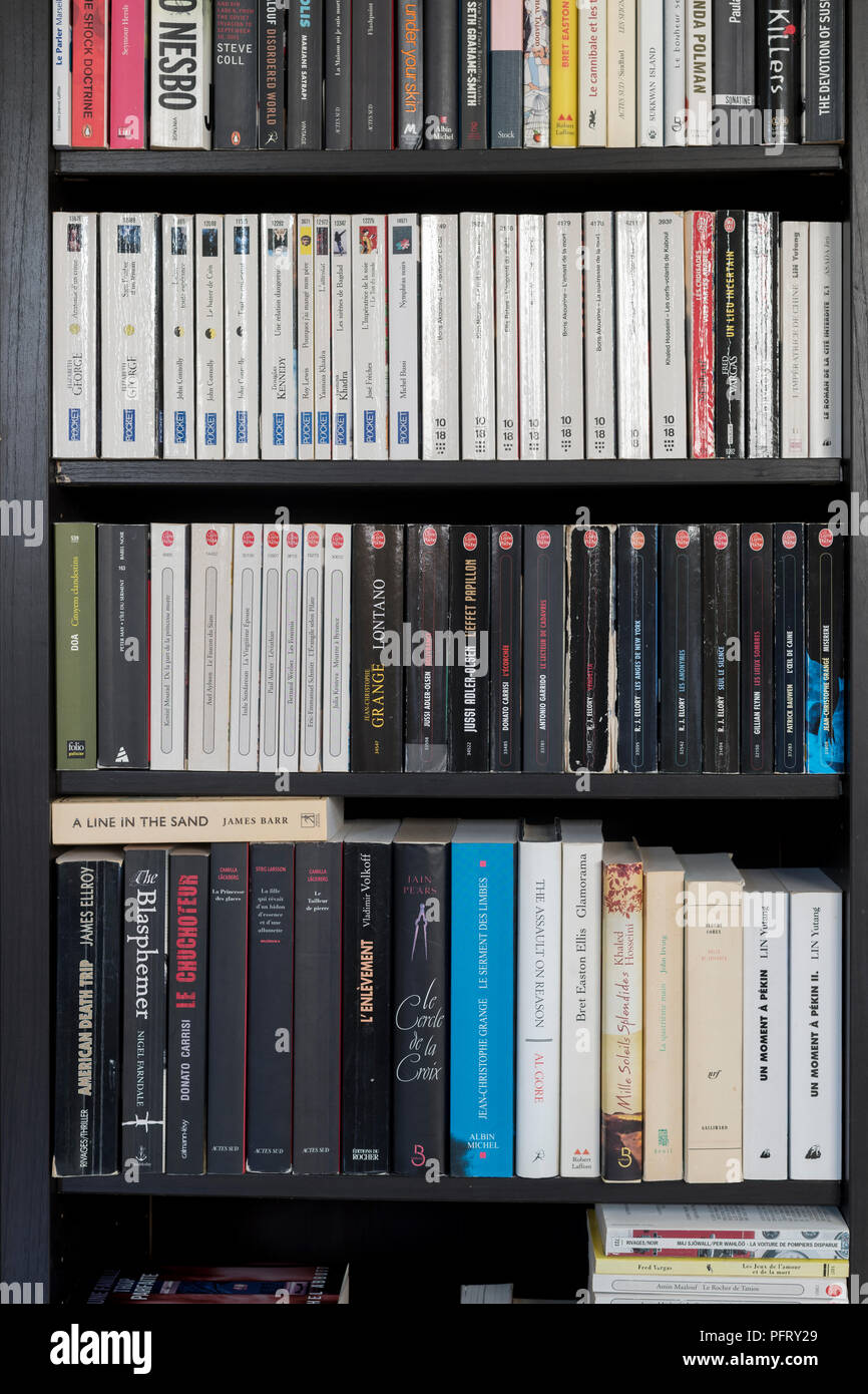Close-up of a home bibliothèque avec livres en français et en anglais  organisés sur des étagères brun foncé Photo Stock - Alamy