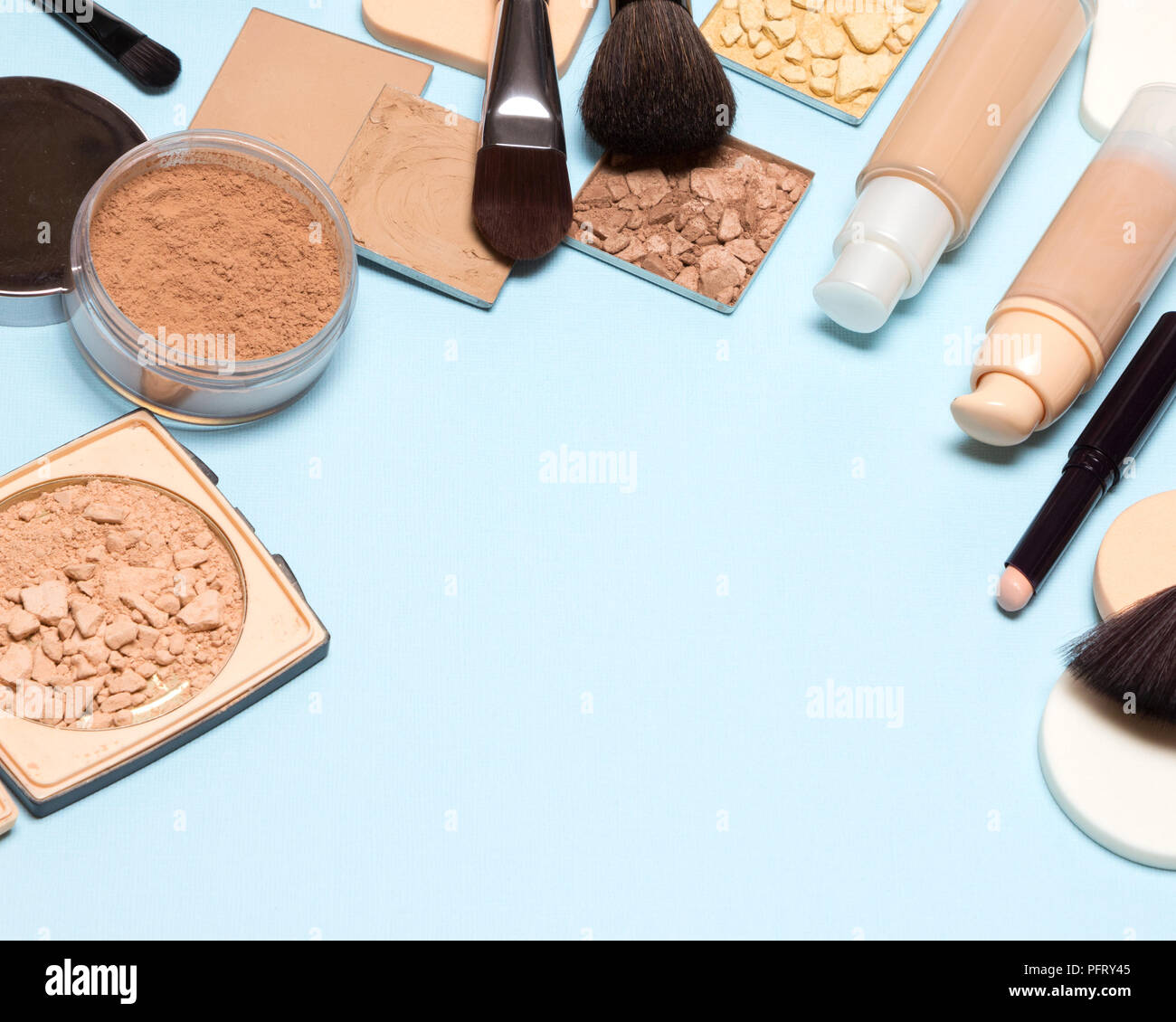 Produits de maquillage de châssis pour la création d'une belle peau ton : concealer, foundation, cosmétique poudre sur fond bleu Banque D'Images