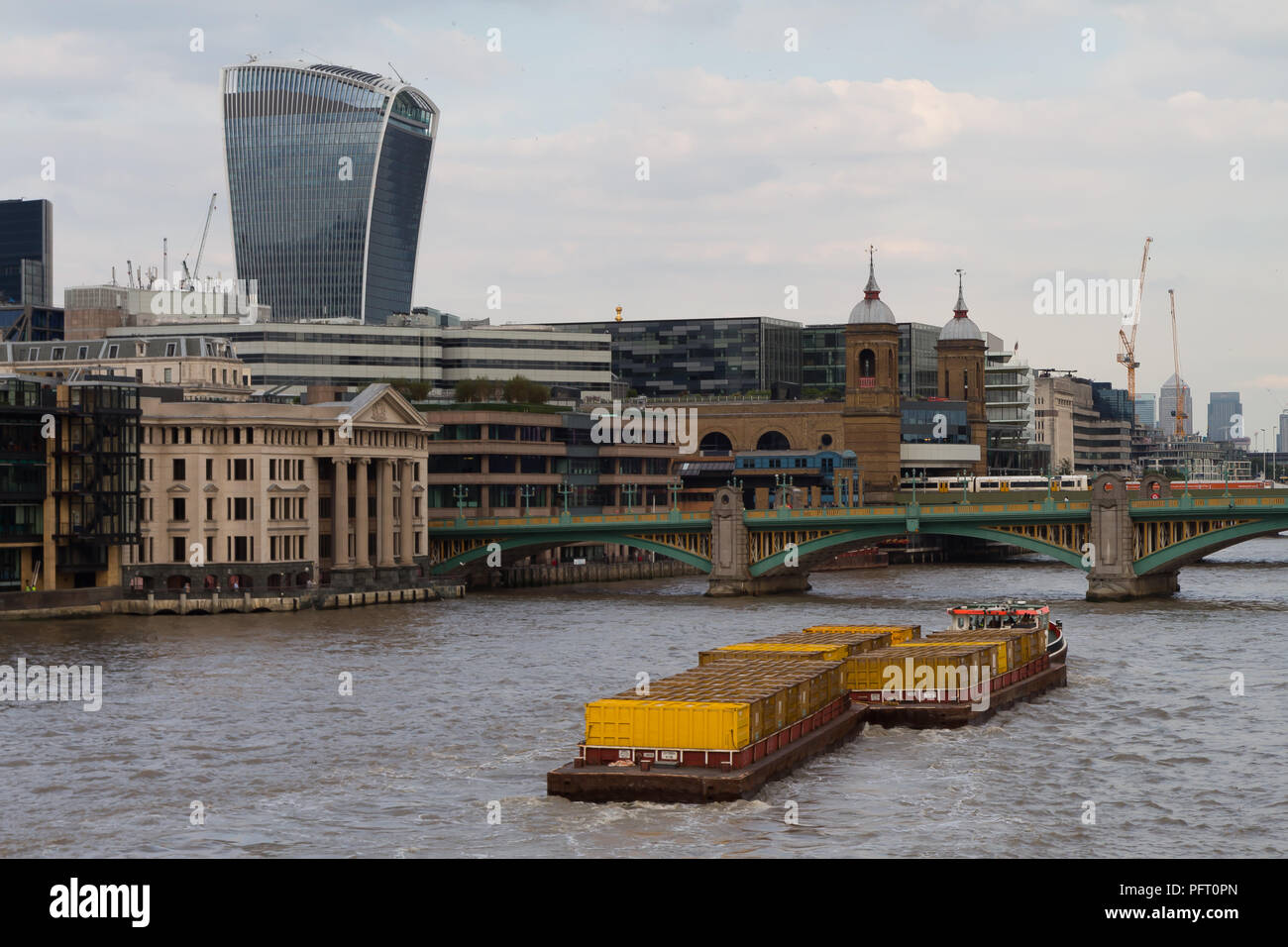 Août 2017, River Thames, London, UK - remorqueur remorquer avec barges conteneurs jaune plein de déchets ménagers ; utilisation du transport fluvial de réduire la congestion un Banque D'Images