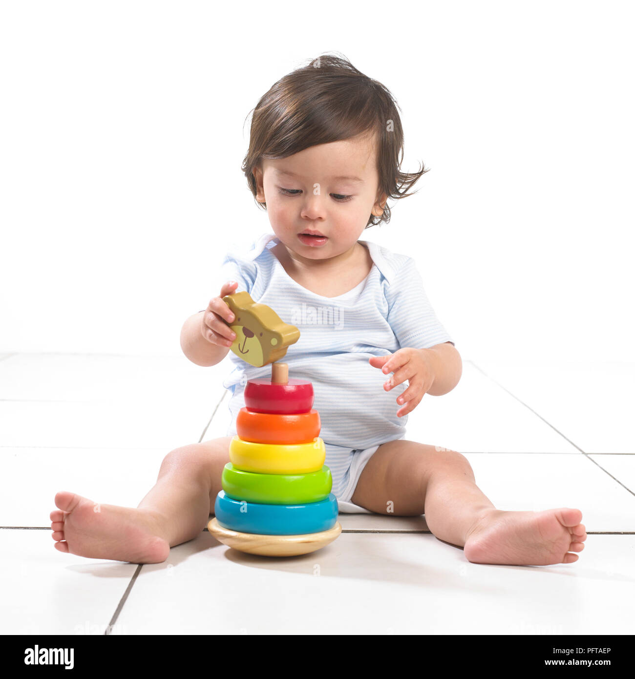 Bébé Garçon jouant avec anneaux jouet empilable Banque D'Images