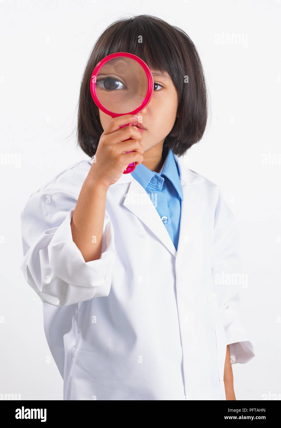 Girl in lab coat à la loupe, à travers 5 ans Banque D'Images