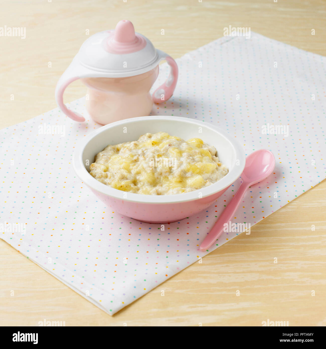 Porridge à la banane, et en plastique mug, les aliments pour bébés ou enfants pour l'alimentation Banque D'Images