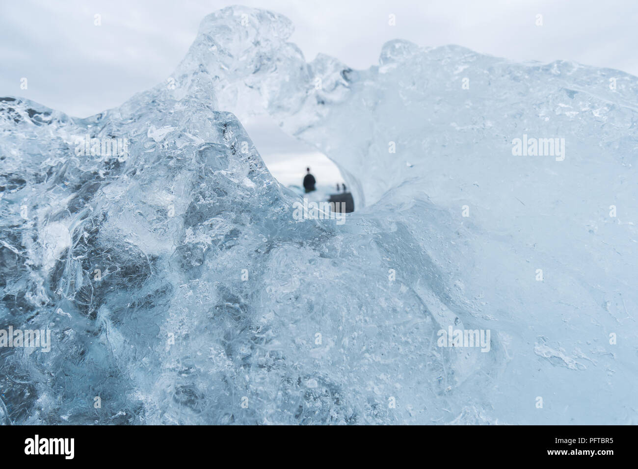 À travers le trou dans un iceberg donne une vue unique de touristes sur la plage du Diamant en Islande. Banque D'Images À travers le trou dans un iceberg donne une vue unique de touristes sur la plage du Diamant en Islande. Banque D'Images