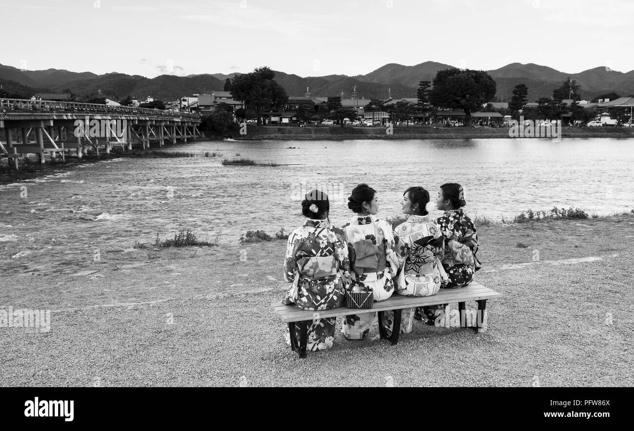 Les amis de s'asseoir ensemble et de se parler à côté de la rivière Katsura Kyodo Japon Banque D'Images