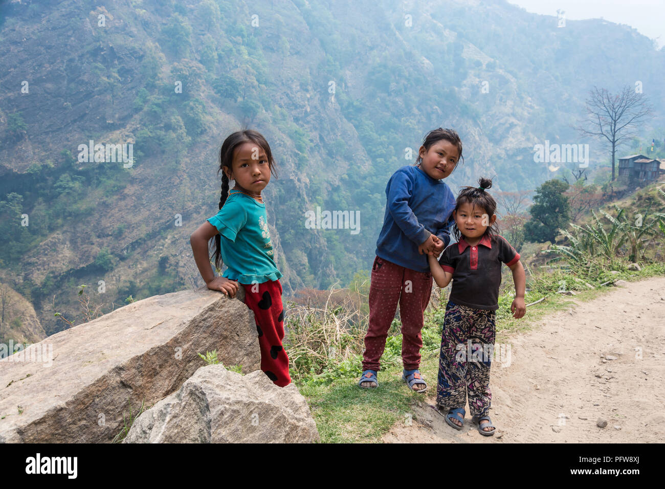 Nepal-March 28, 2018 : trois petites filles se tenir sur le bord de la route de montagne le 28 mars 2018 au Népal. Banque D'Images