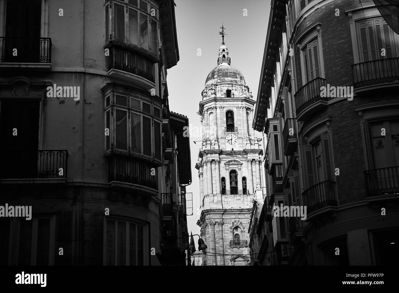 Image en noir et blanc à la recherche à travers une ruelle à la cathédrale de Malaga en Andalousie Espagne bell tower Banque D'Images