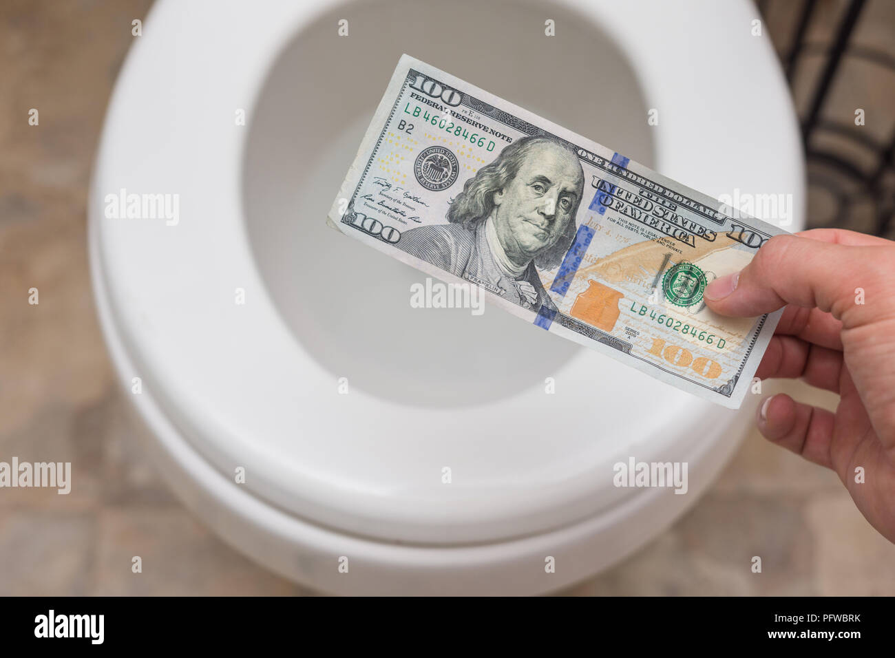 Holding crisp one hundred dollar bill en toilettes ; clena et lumineux ; finances concept Banque D'Images