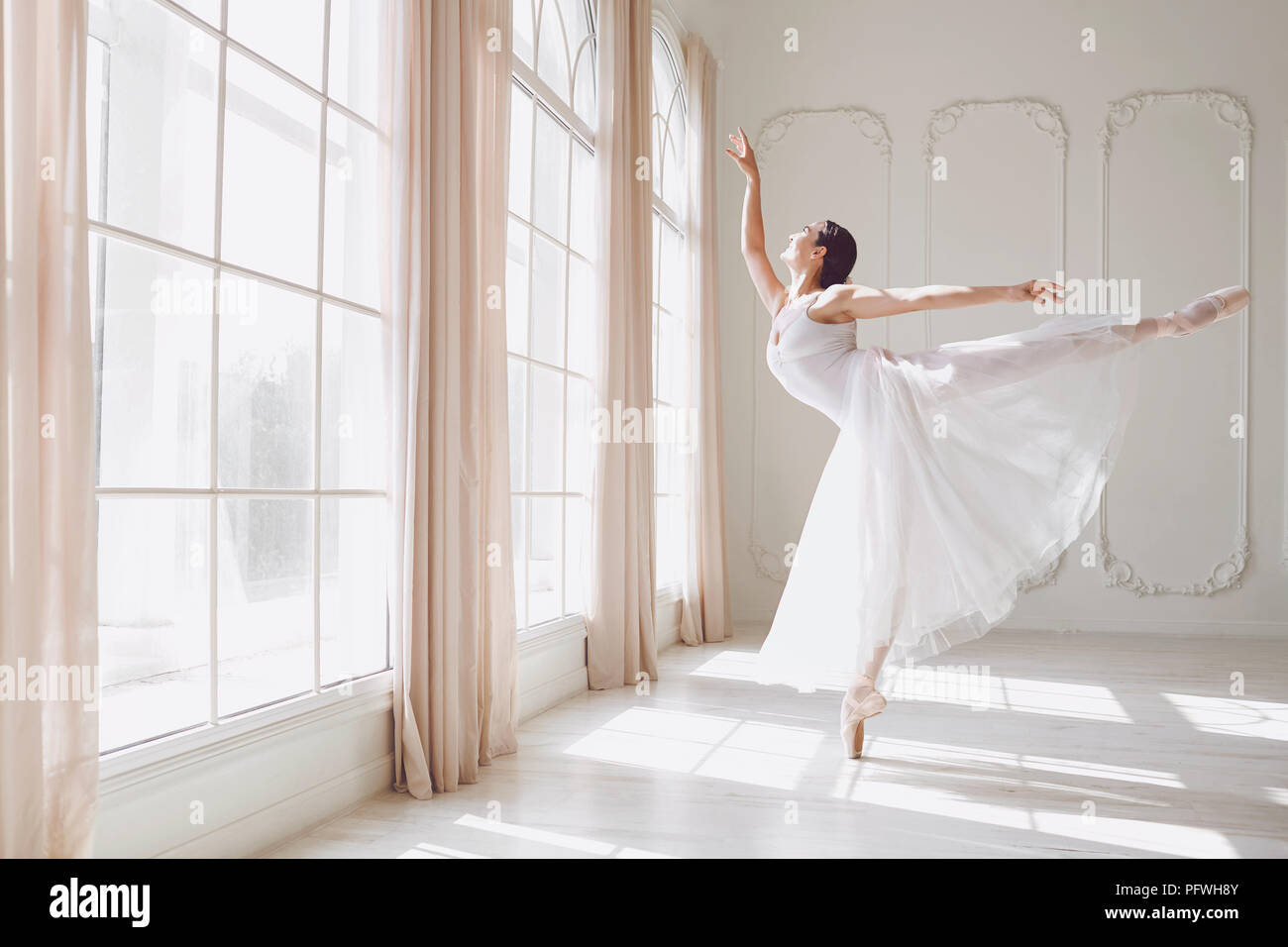 Ballerine dansant dans un studio sur fenêtre d'arrière-plan. Banque D'Images