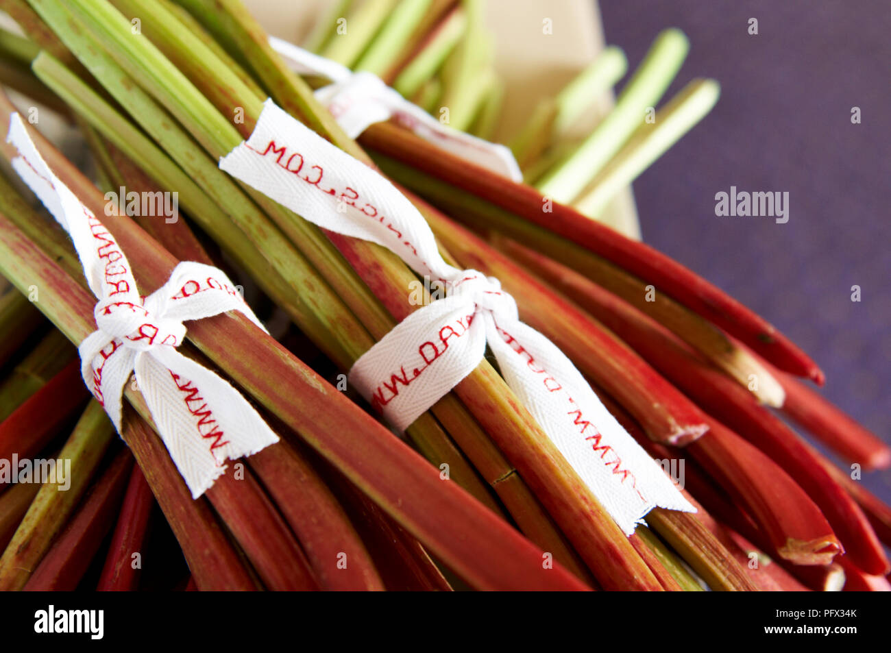 Bouquets de tiges de rhubarbe bio à la vente à un décrochage du marché. Banque D'Images