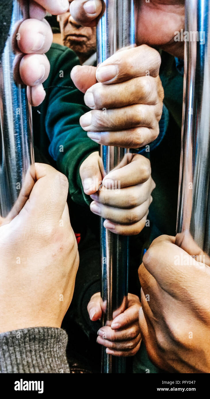 Libre, les gens mains tenant la main courante à l'intérieur du train. Banque D'Images