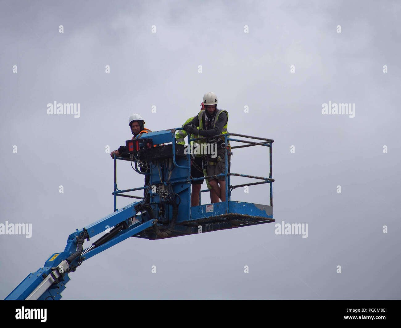 Trois travailleurs d'une grue à l'huilding d'une scène pour un festival de musique Banque D'Images