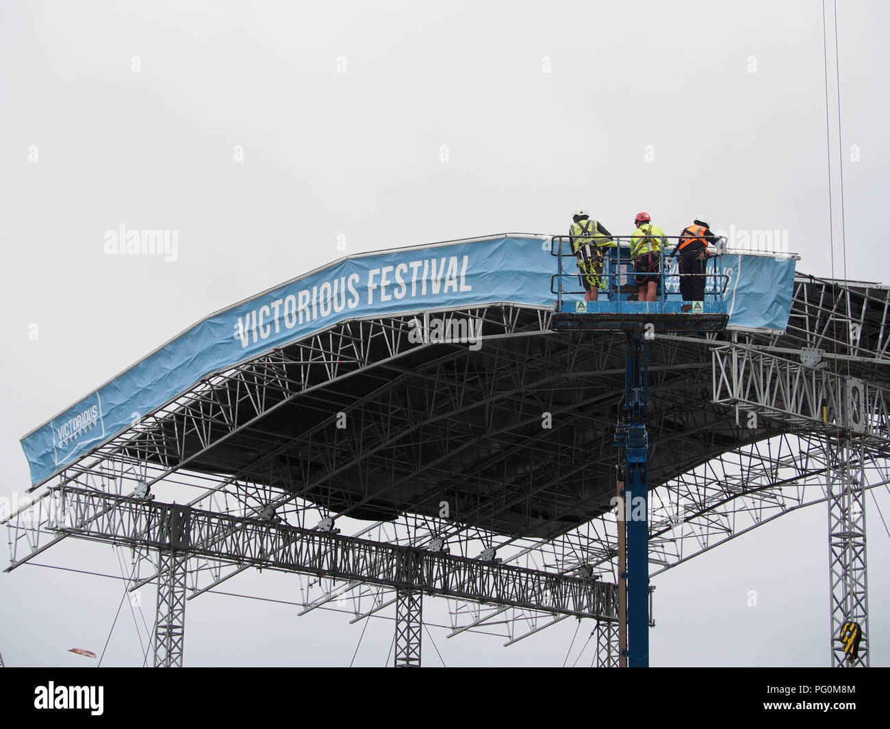 Trois travailleurs d'une grue à l'huilding d'une scène pour un festival de musique Banque D'Images