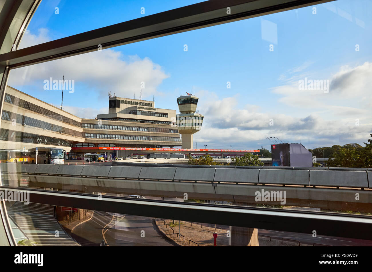 Berlin, Allemagne - 15 août 2018 : l'aéroport de Tegel bâtiment principal et tour de contrôle du trafic aérien vu à travers une fenêtre dans la matinée. Banque D'Images