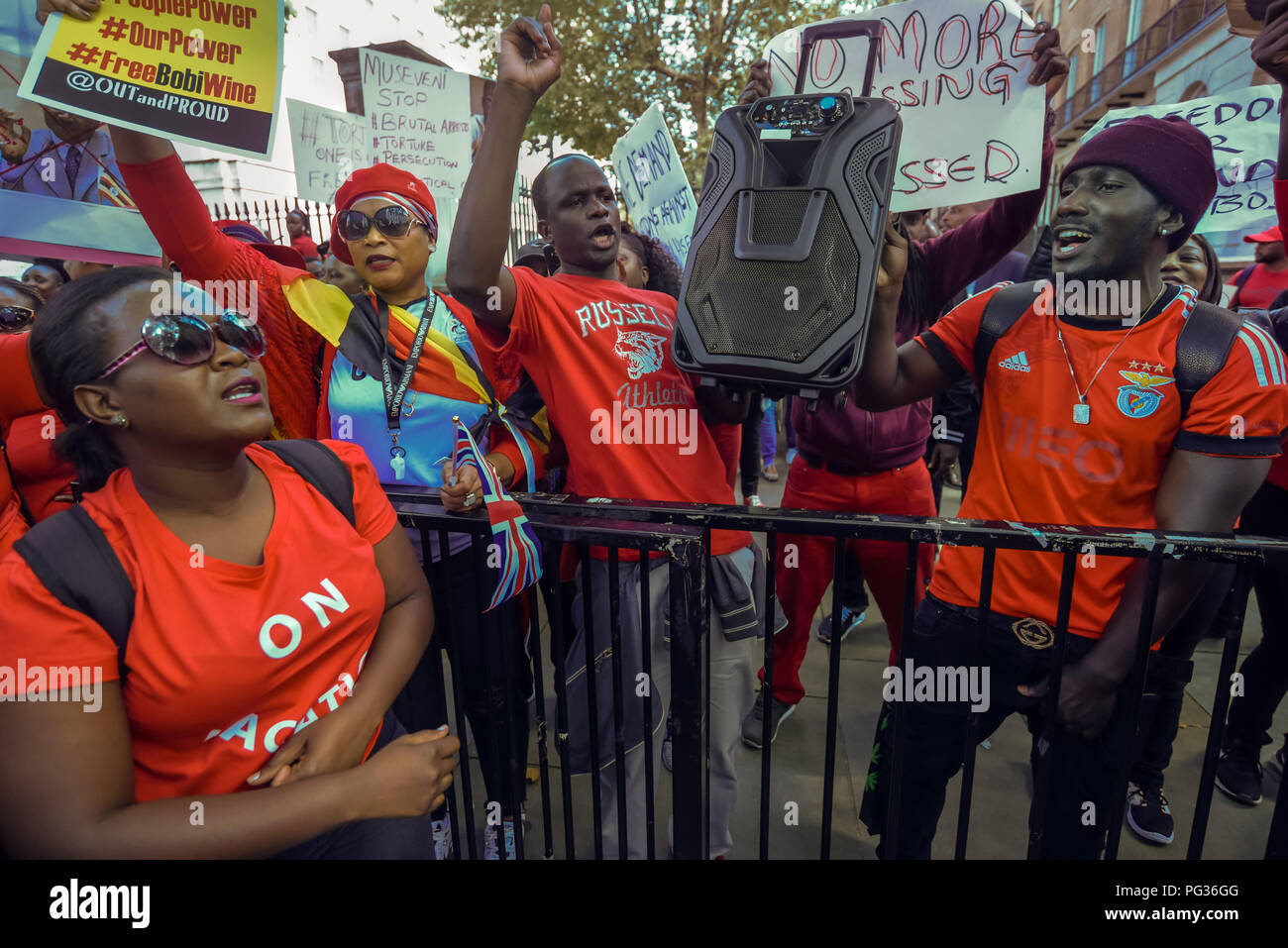 Londres, Royaume-Uni. 23 août 2018. Des centaines d'Ougandais, principalement vêtus de rouge, de protestation à Downing St à dire que le Président Museveni doit aller. Ils l'accusent d'être un dictateur, et a appelé à la fin et à l'assassinat de politiciens de l'opposition et pour la libération des personnes emprisonnées, y compris l'homme d'affaires, député et le chanteur Bobby Kyagulanyi Ssentamu Robert (Vin), et la fin de l'accaparement des terres. Crédit : Peter Marshall/Alamy Live News Banque D'Images