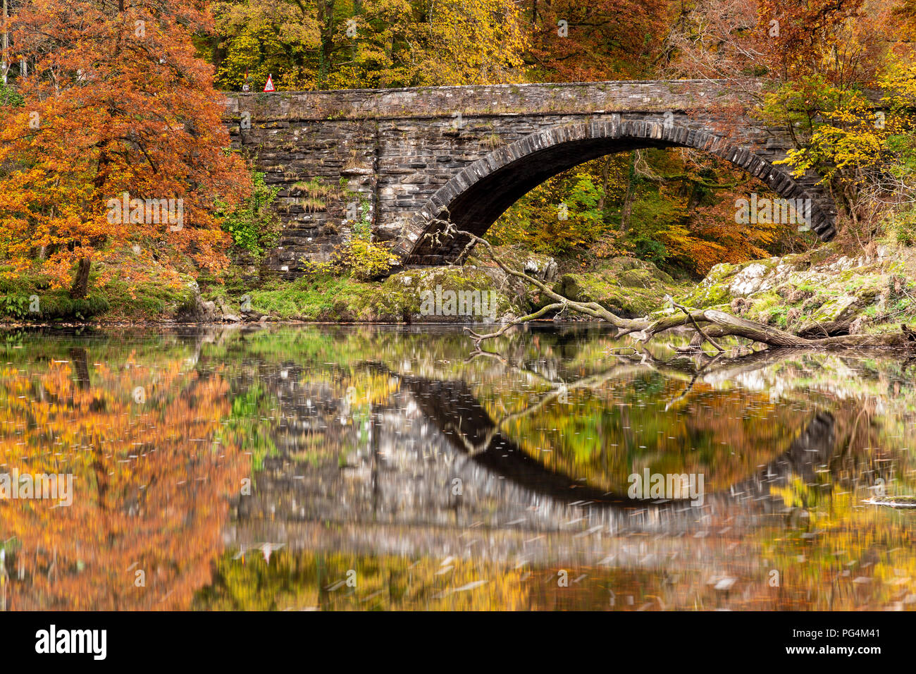 Vieux pont de pierre se reflétant dans la rivière Conwy, au nord du Pays de Galles à l'automne près de Betws-Y-coed, Snowdonia, Banque D'Images