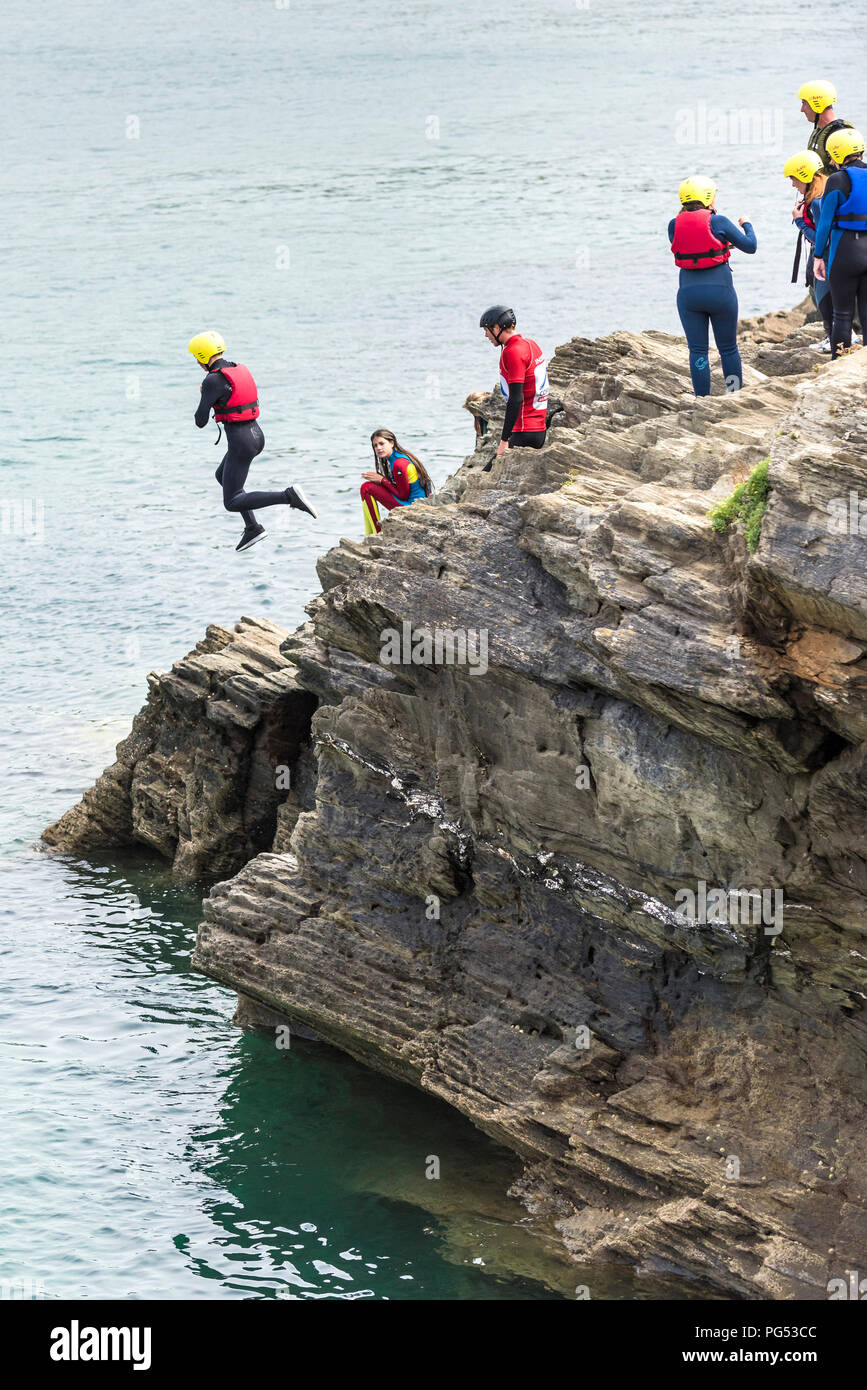 Les vacanciers sur la pointe de coasteering Newquay, Cornwall. Banque D'Images