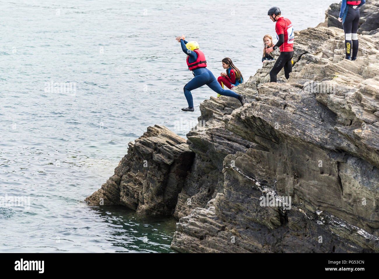 Les vacanciers sur la pointe de coasteering Newquay, Cornwall. Banque D'Images