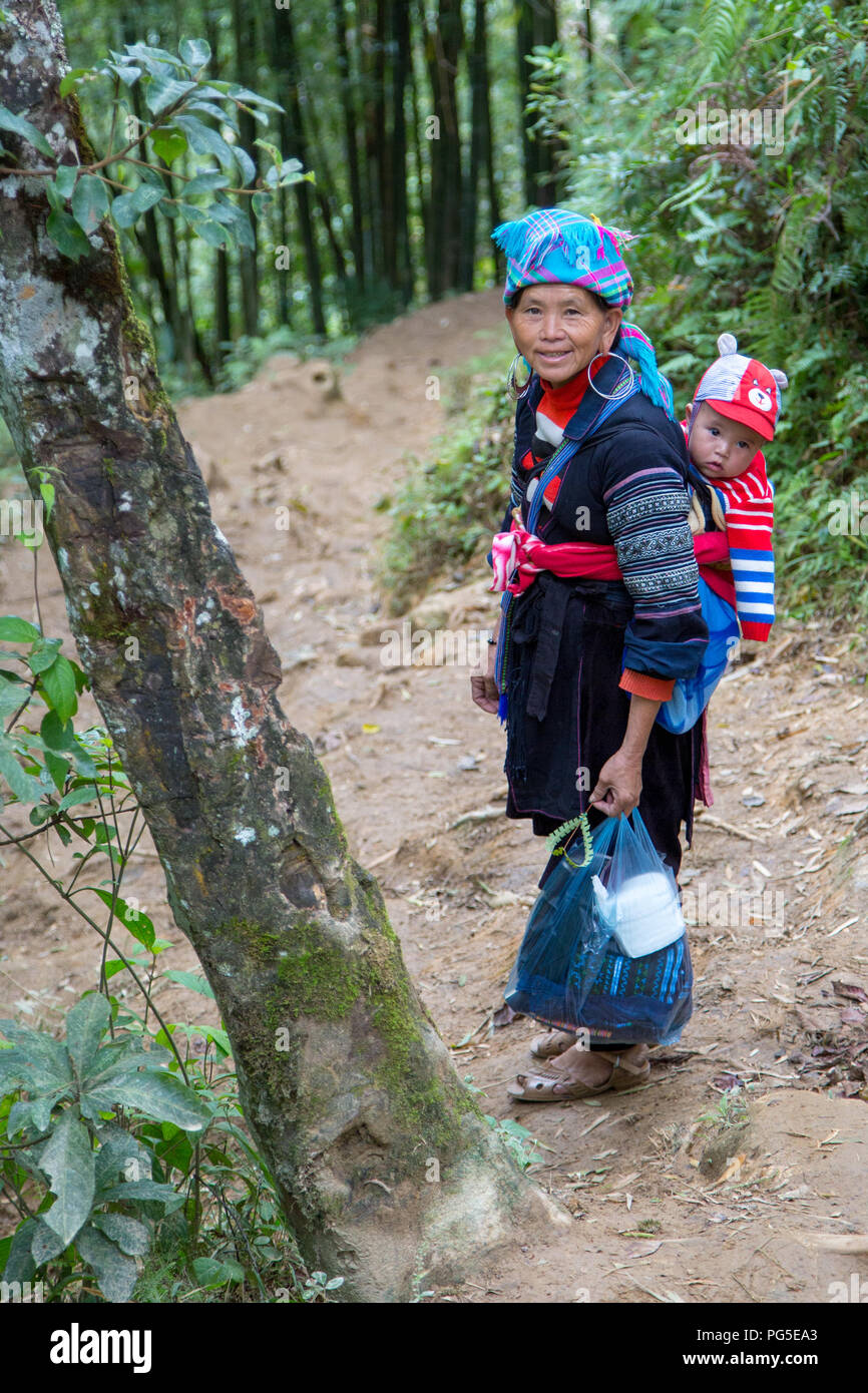 Une femme de la communauté Hmong Fleurs et son petit-fils près de Sapa, Vietnam Banque D'Images
