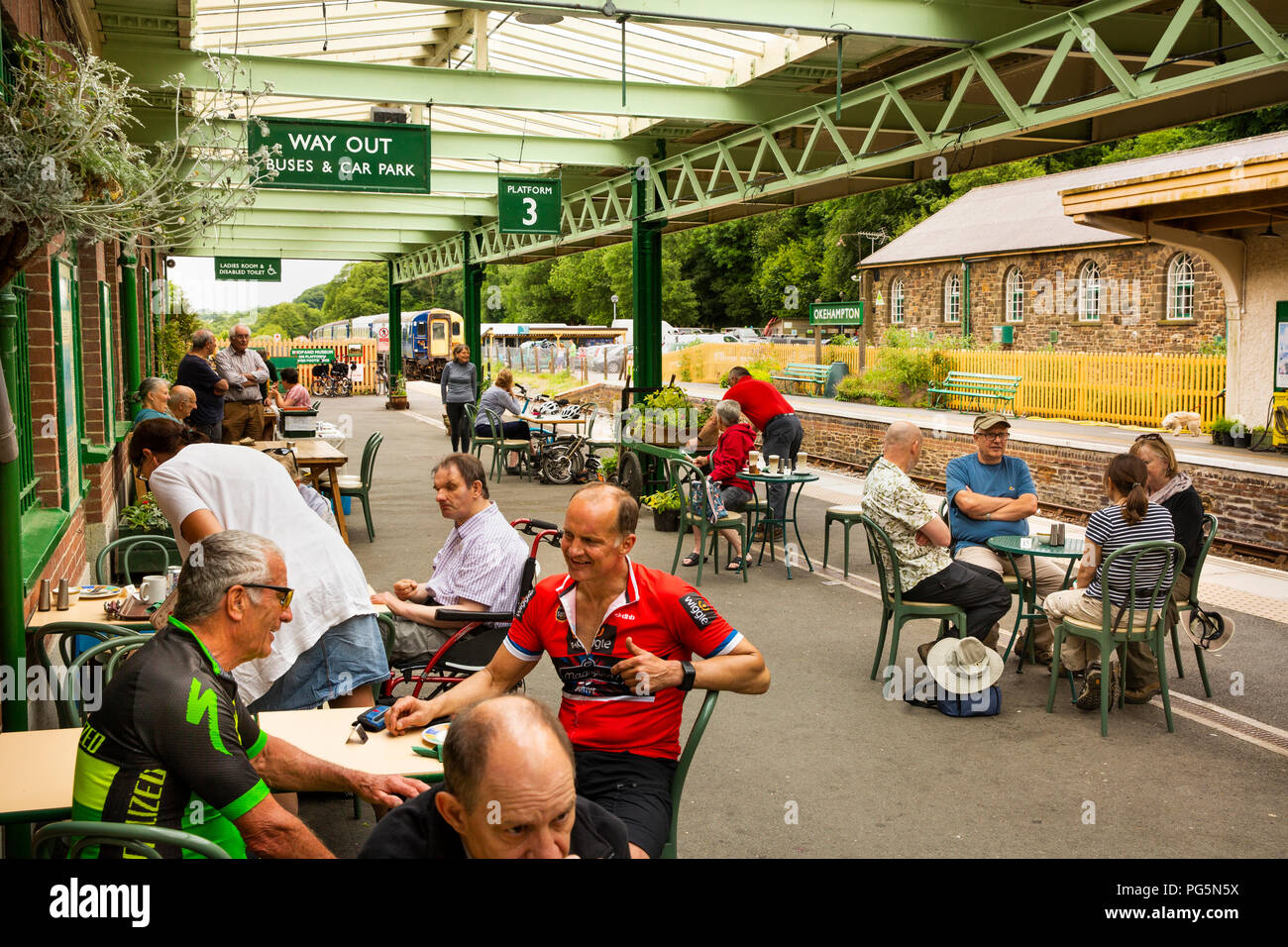 Royaume-uni, Angleterre, Devon, Okehampton, gare, les passagers à buffet tables sur la plate-forme Banque D'Images