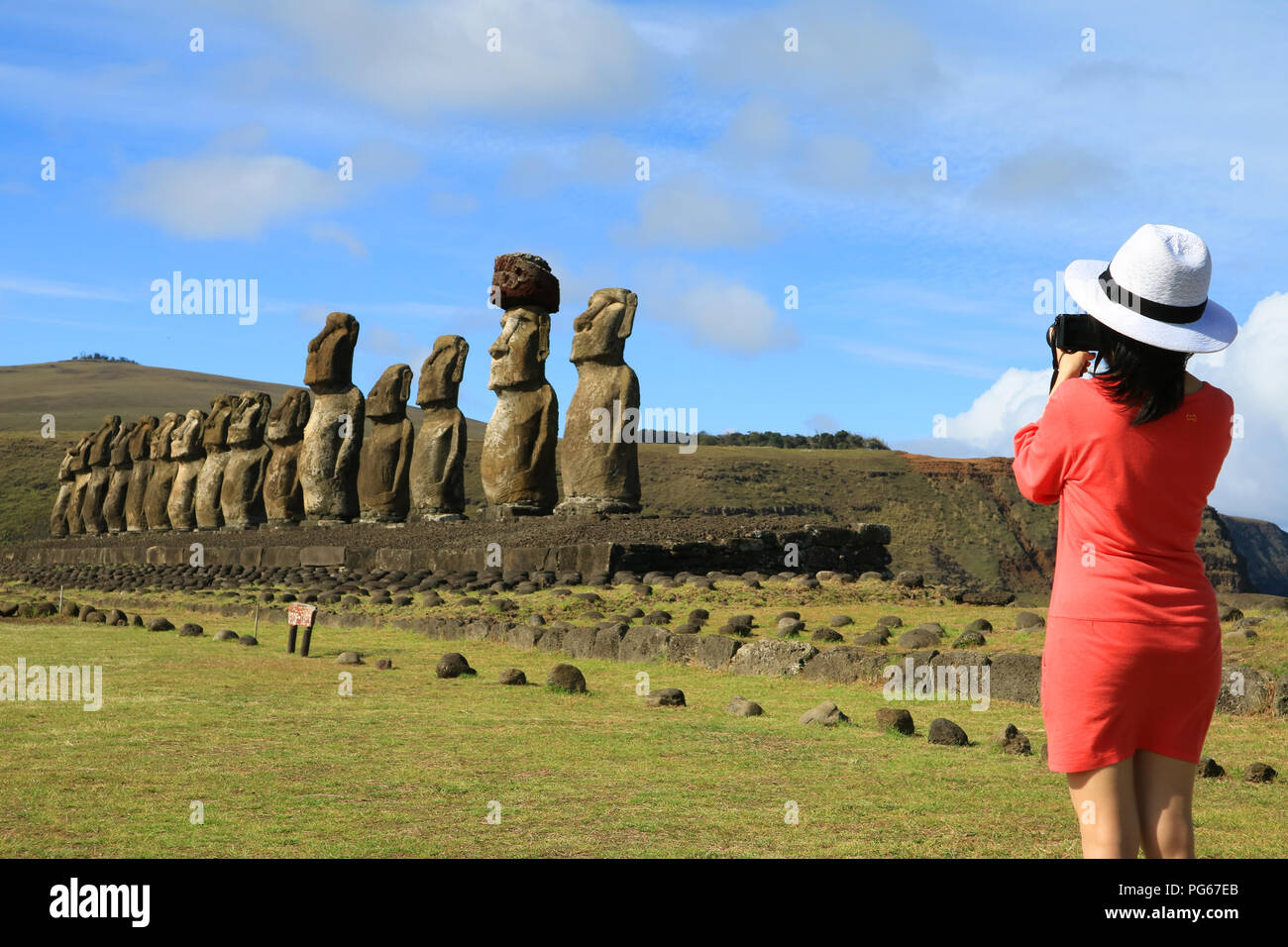 Jeune femme à prendre des photos de la fameuse statues Moai de l'ahu Tongariki sur l'île de Pâques, site archéologique au Chili Banque D'Images