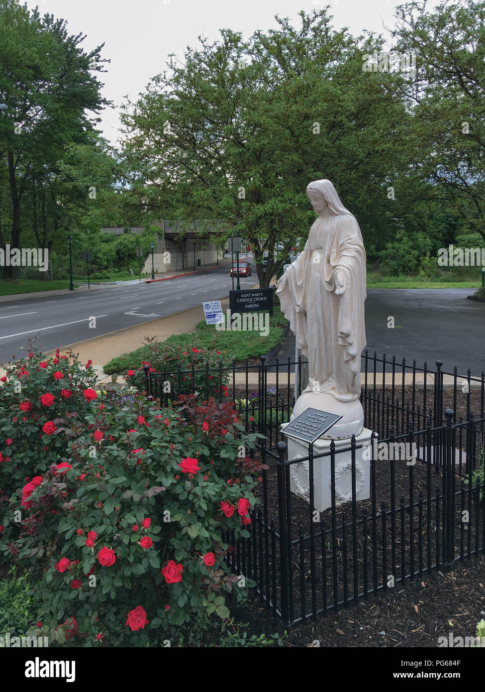 Belle Vierge Marie Mère sereine foi chrétienne Religion spirituelle Memorial Monument Sculpture Statue Jardin de roses à l'extérieur de l'Église Catholique Banque D'Images