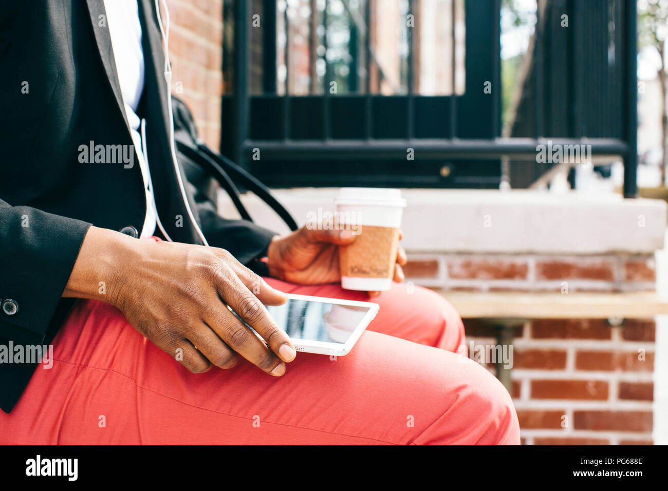 Homme assis dans la rue, à l'aide de tablette numérique, boire du café Banque D'Images