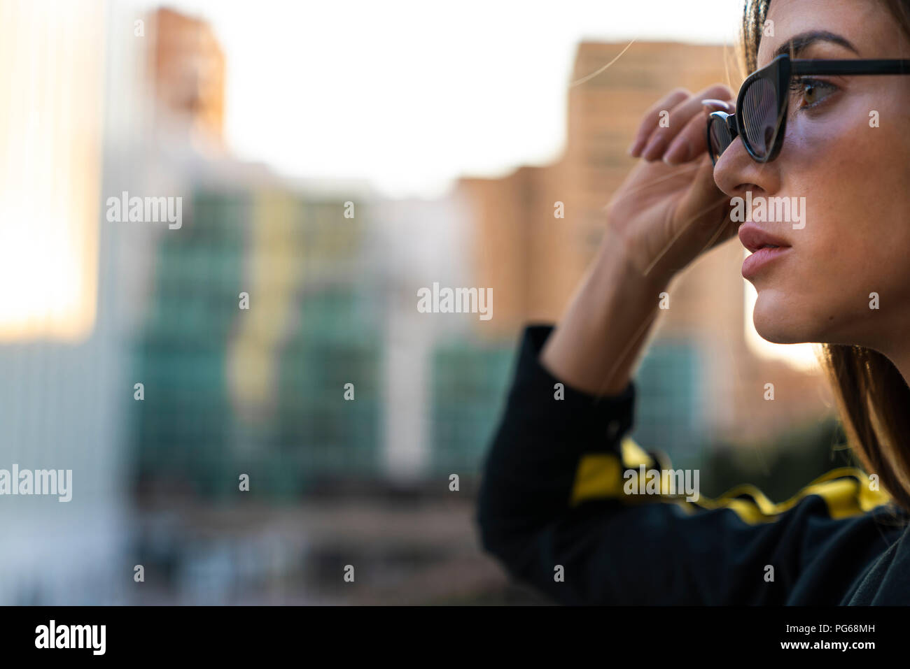 Portrait of attractive young woman wearing sunglasses dans la ville Banque D'Images