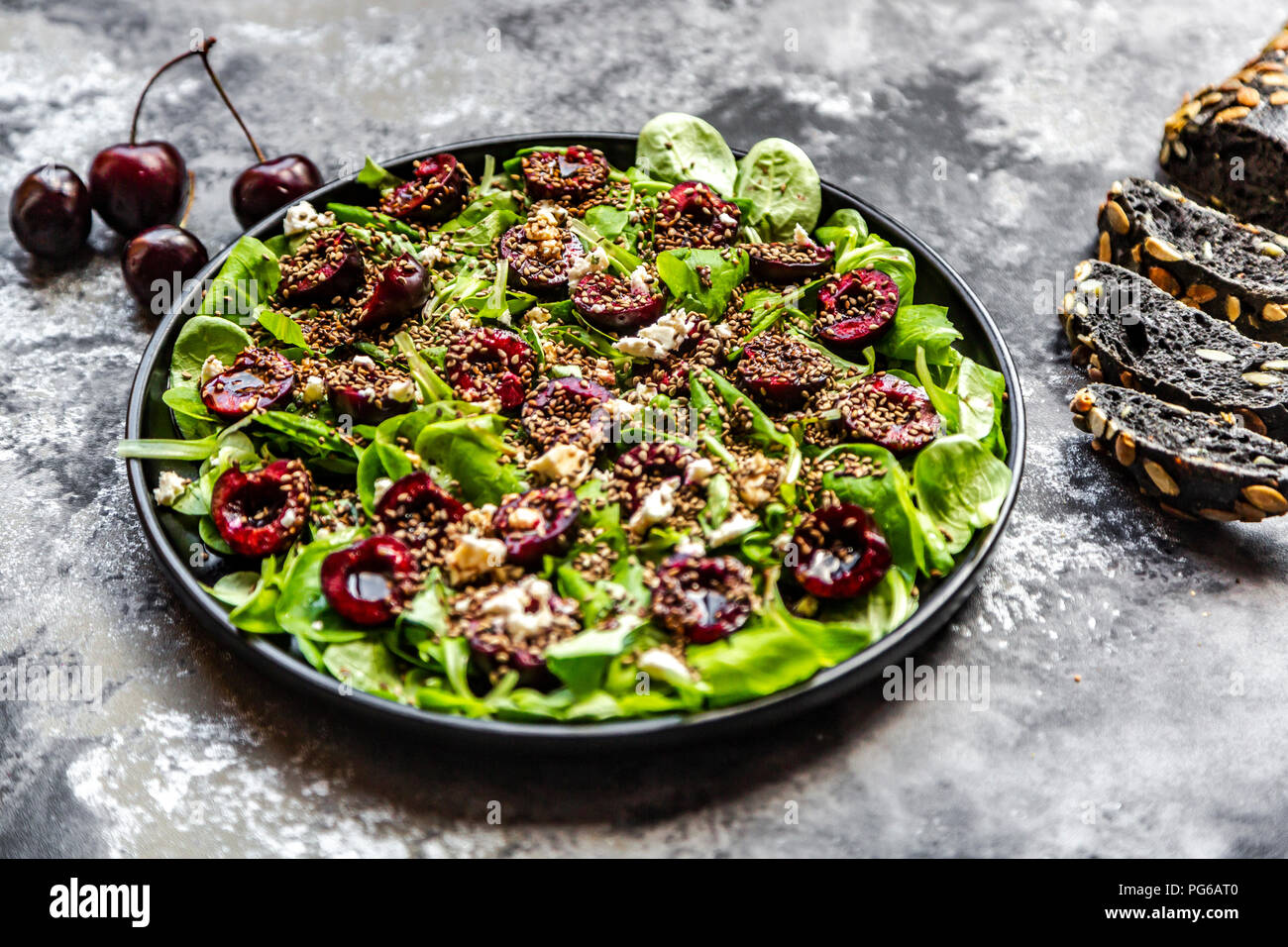 La mâche avec cerises, fromage feta, sépia Noir et sésame grillé du pain d'épeautre Banque D'Images