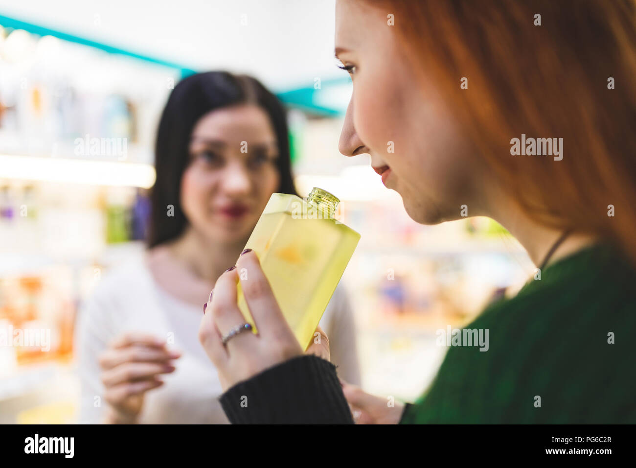 Deux femmes dans une boutique de cosmétiques d'essayer le parfum Banque D'Images