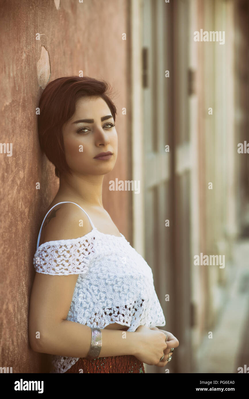 Belle jeune femme appuyée contre le mur à l'extérieur Banque D'Images