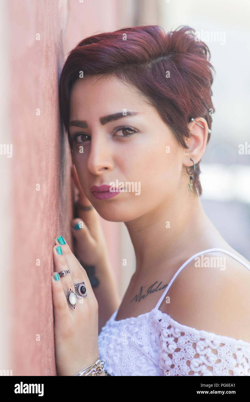 Belle jeune femme appuyée contre le mur à l'extérieur Banque D'Images