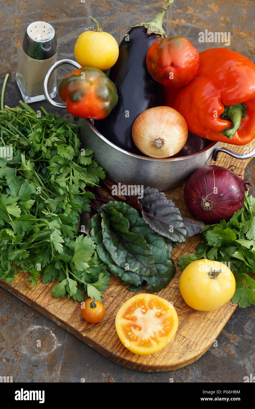 Poivron rouge frais , l'aubergine et l'oignon en pot avec tomates, persil, coriandre mangold sur fer backgrownd Banque D'Images