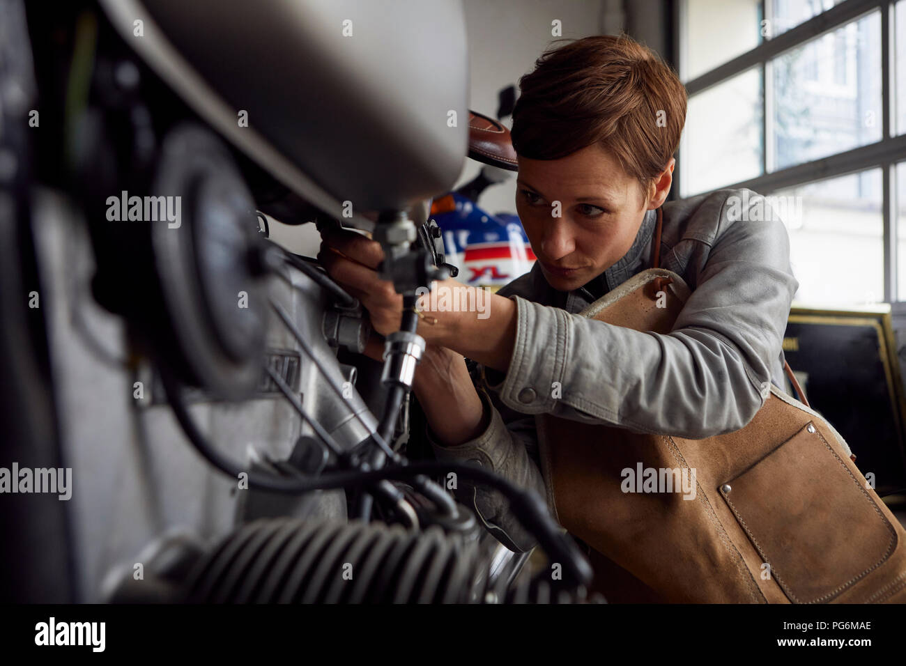 Femme travaillant en atelier de réparation Banque D'Images