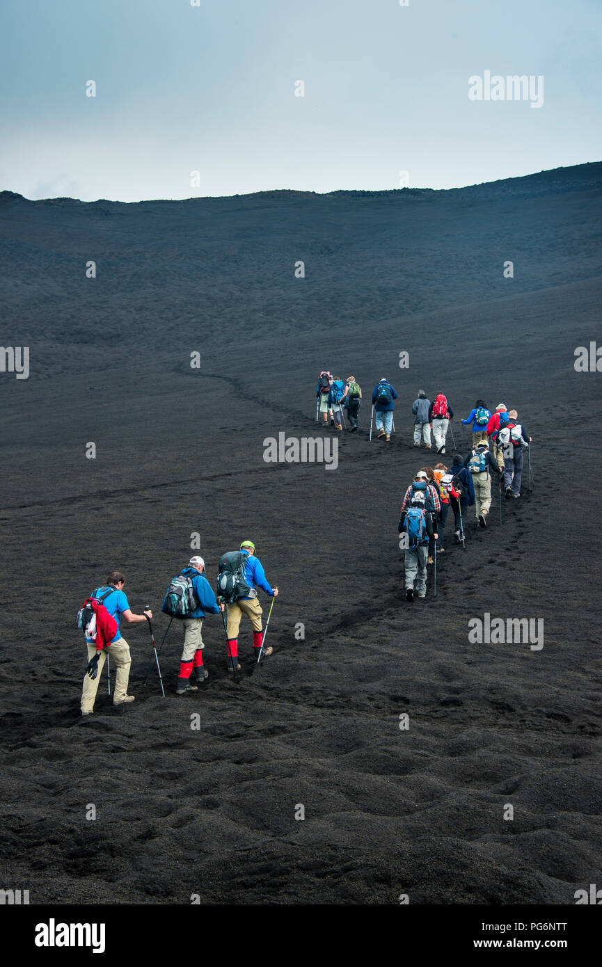 Les touristes à marcher en ligne à travers la lave sables du volcan Tolbachik, le Kamchatka, Russie Banque D'Images