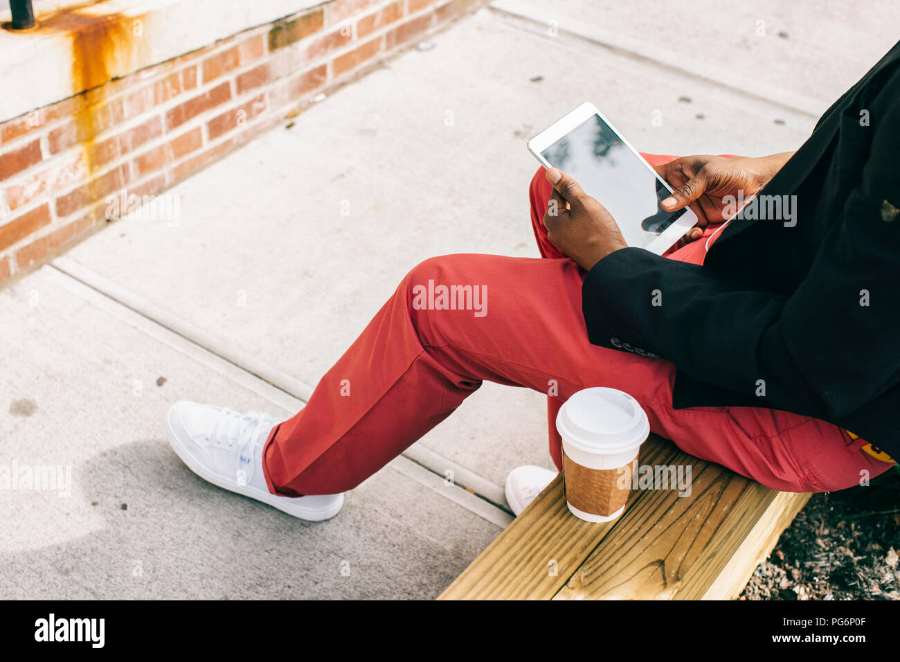 Homme assis dans la rue, à l'aide de tablette numérique, boire du café Banque D'Images