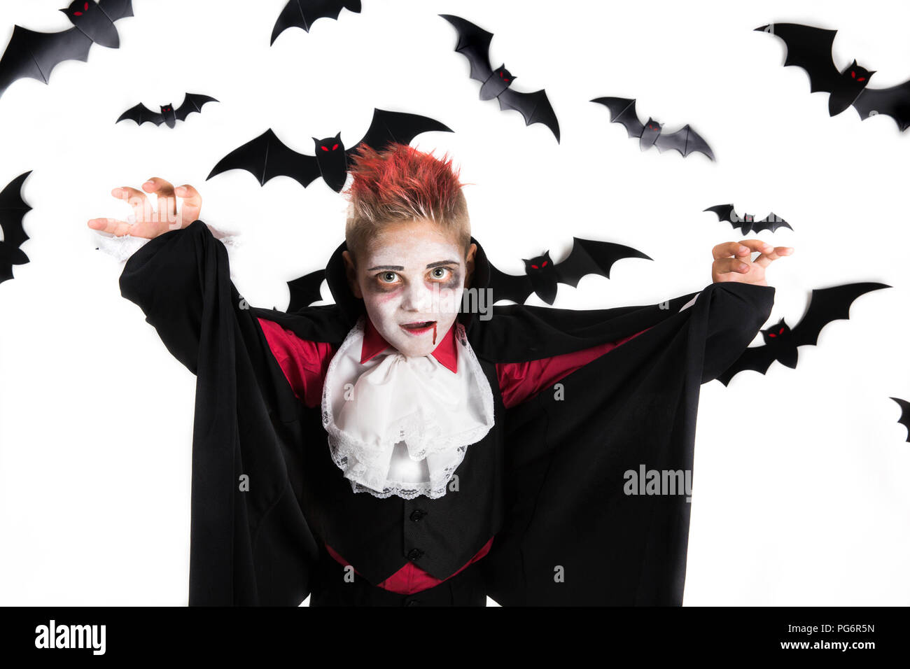 Scary Halloween vampire garçon habillé pour Spooky Halloween party et tenant une orange halloween citrouille Jack o lantern Banque D'Images