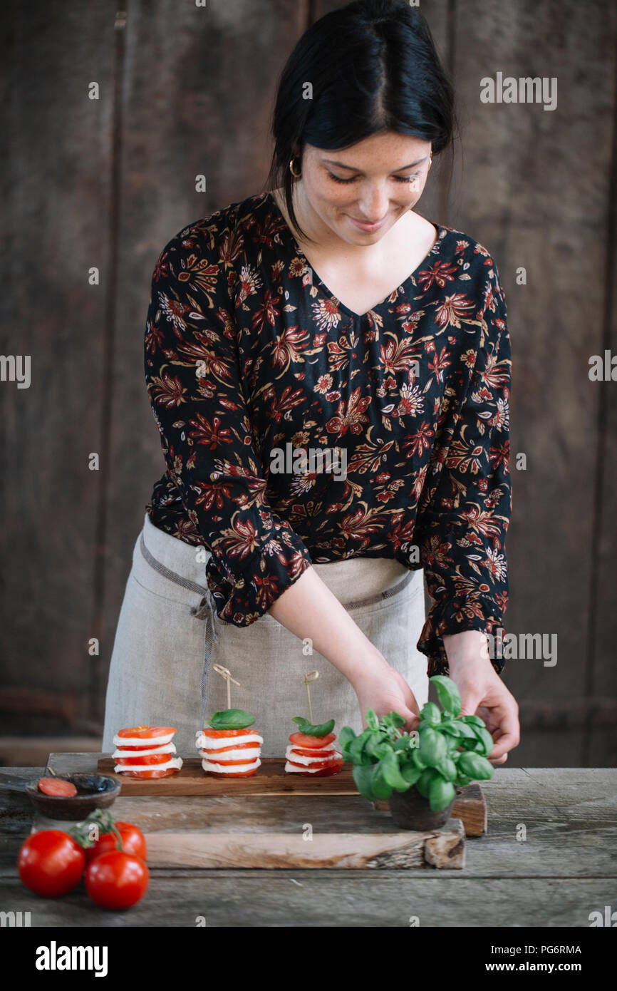 Femme préparant salade caprese Banque D'Images