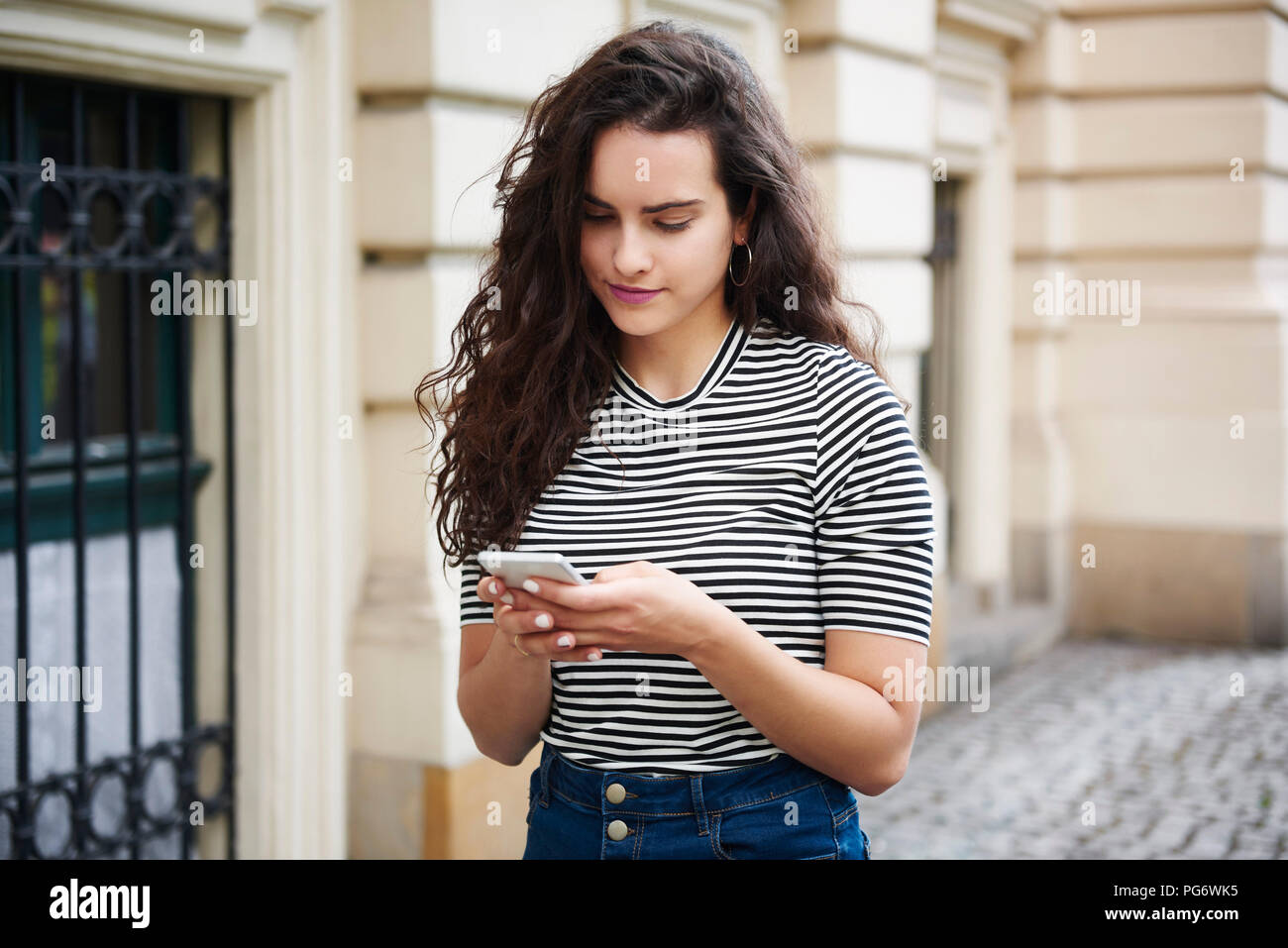 Young woman using cell phone in the city Banque D'Images
