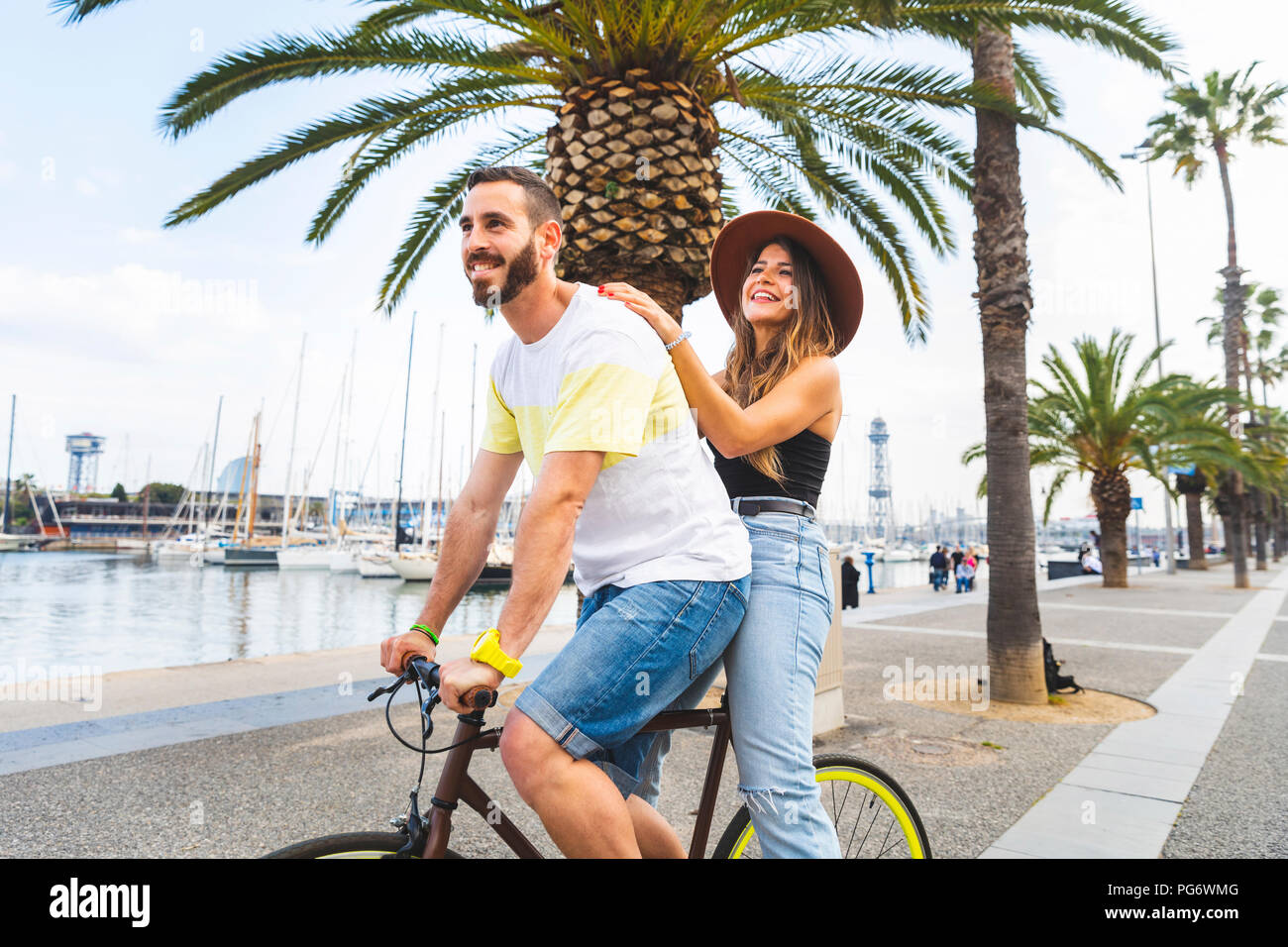 Espagne, Barcelone, couple et le partage d'un trajet sur un vélo ensemble à la promenade du bord de mer Banque D'Images
